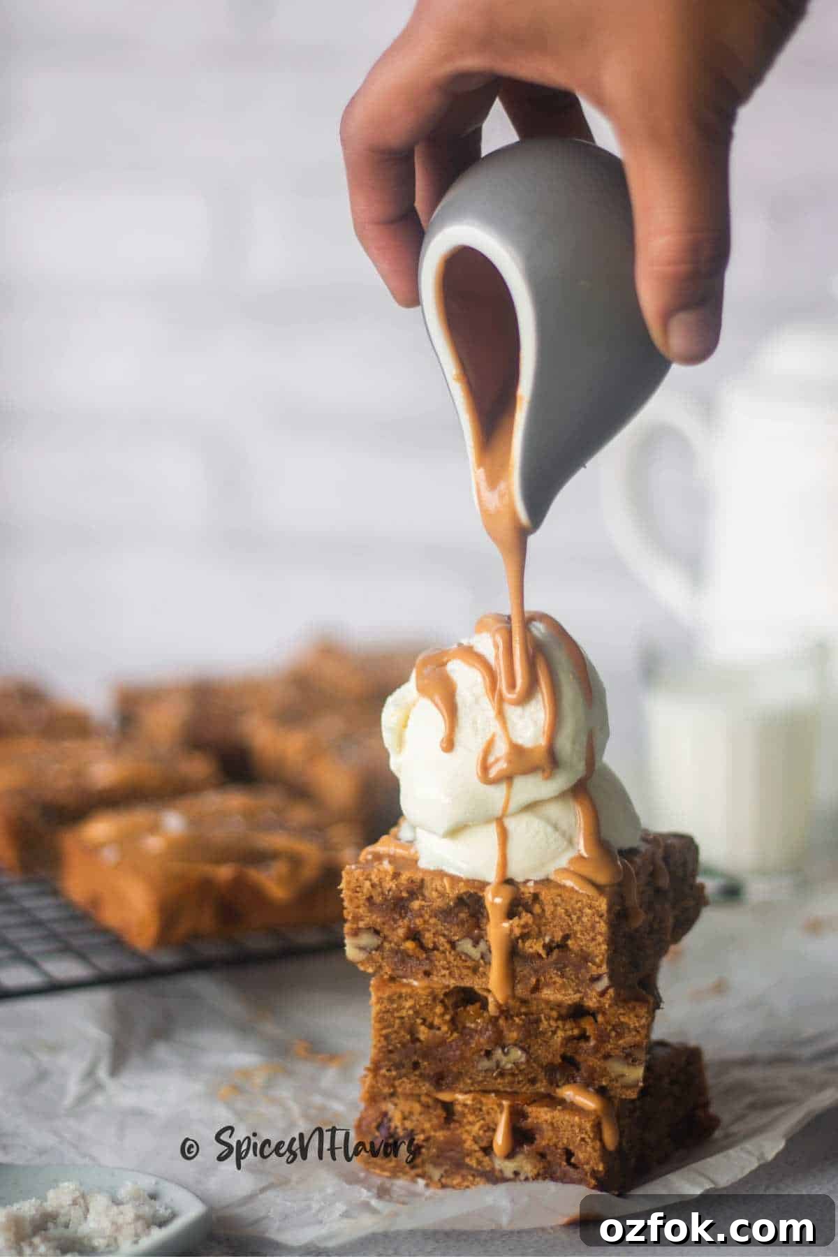 Eggless Butterscotch Blondie Recipe — Moist, Chewy Bars 9 pouring butterscotch sauce over ice cream placed on stacked brownies