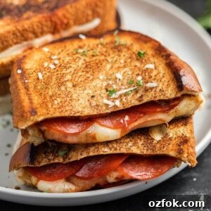 crispy grilled cheese sandwich with pepperoni and herbs, close-up on plate