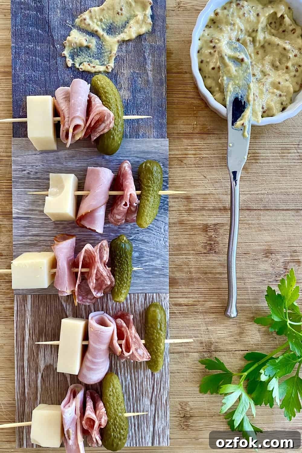 Cuban sandwich appetizer skewers with ham, Swiss cheese, salami and dill pickle.