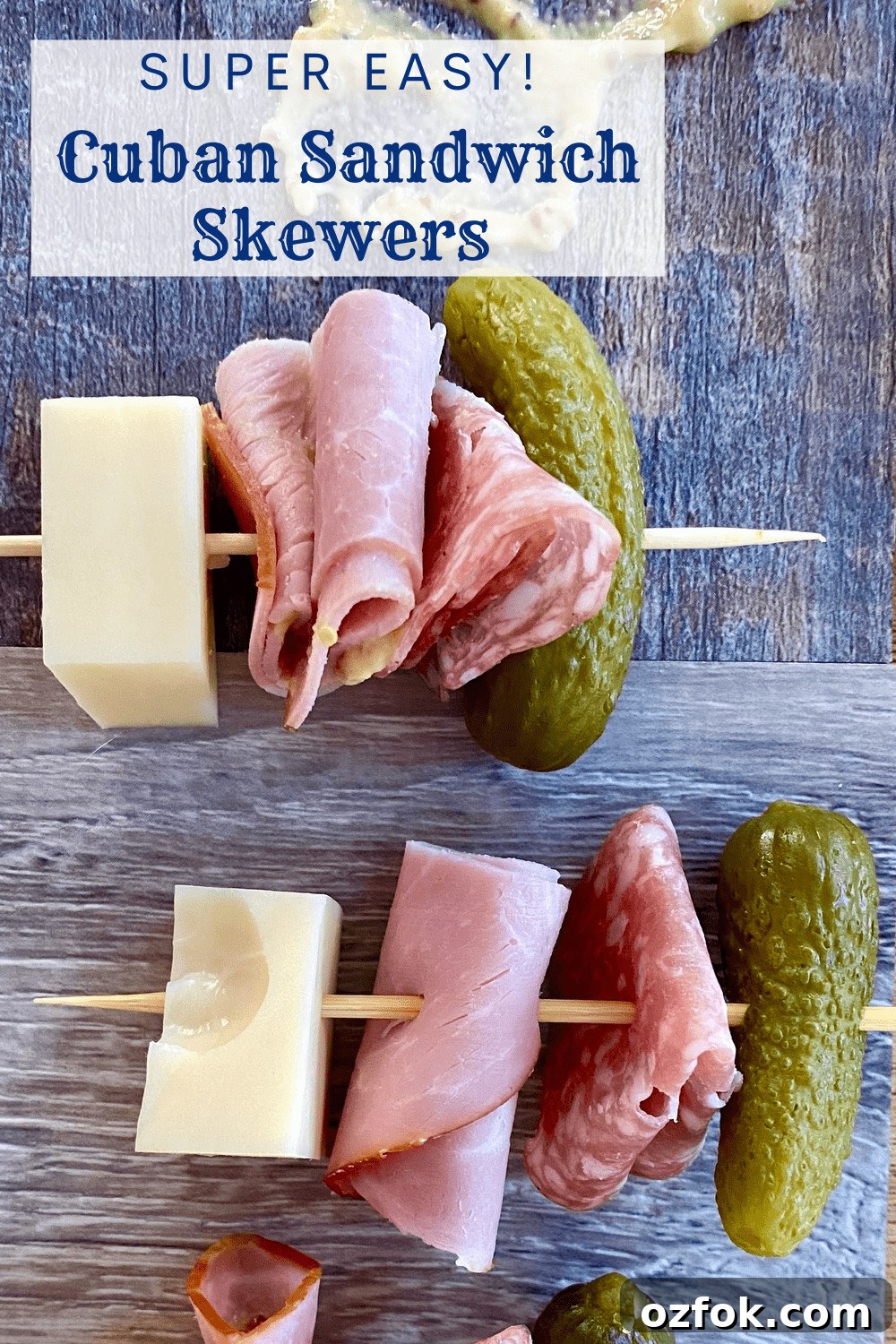 2 skewers with ham, Swiss cheese, salami, and a mini dill pickle.