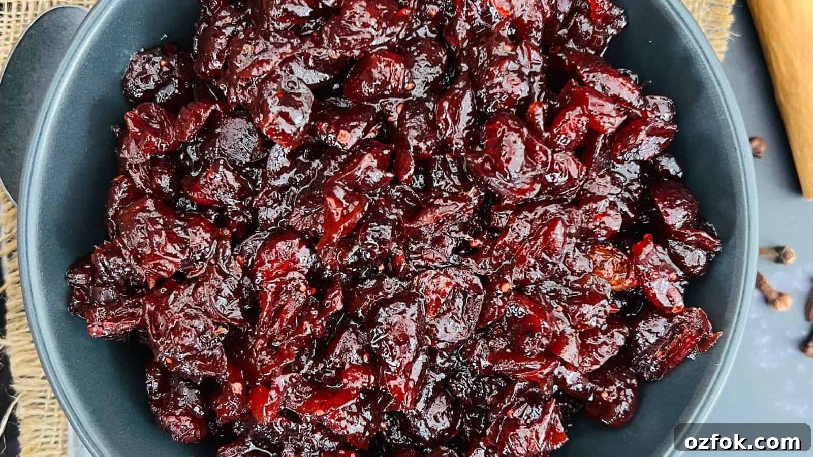 A close-up of a bowl filled with dark red cranberry sauce.