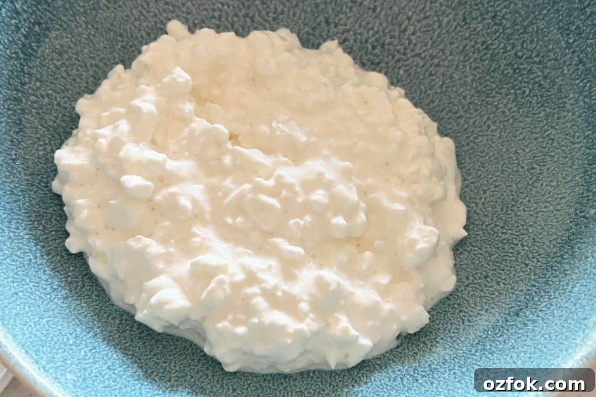 In individual bowls or on a serving platter, place a generous scoop of cottage cheese.