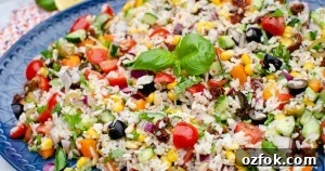Italian Style Rice Salad on a large blue platter plate and basil leaves on top