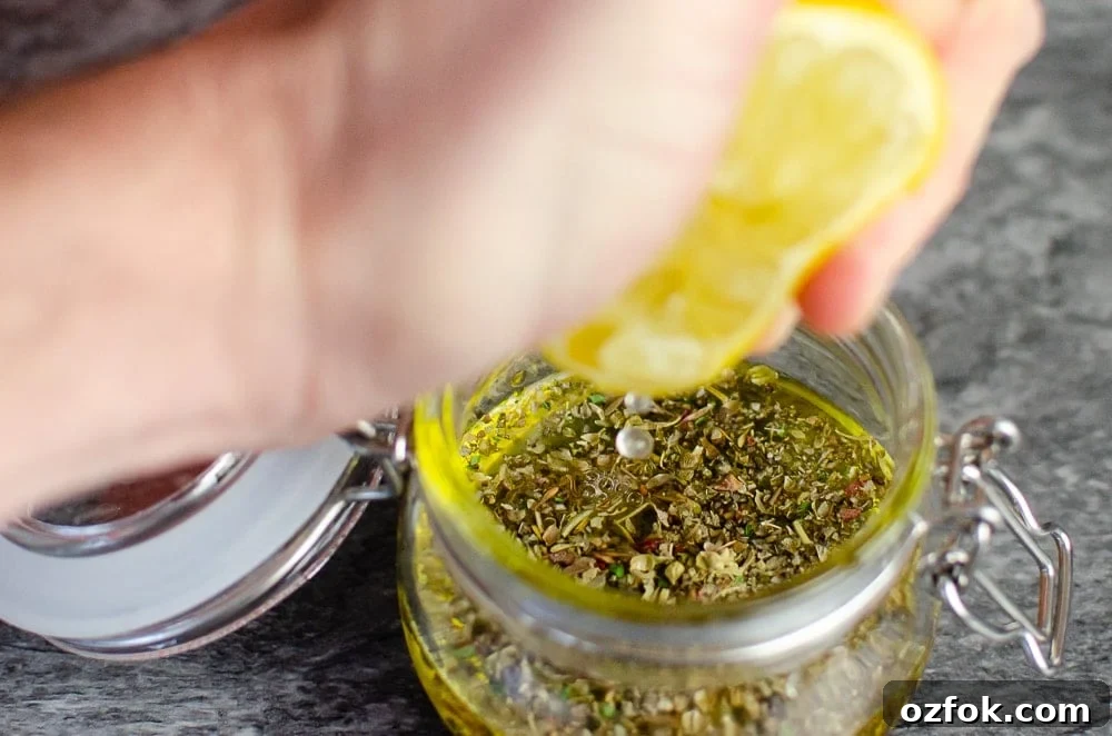 Lemon juice being squeezed into our Italian salad dressing in a glass pot