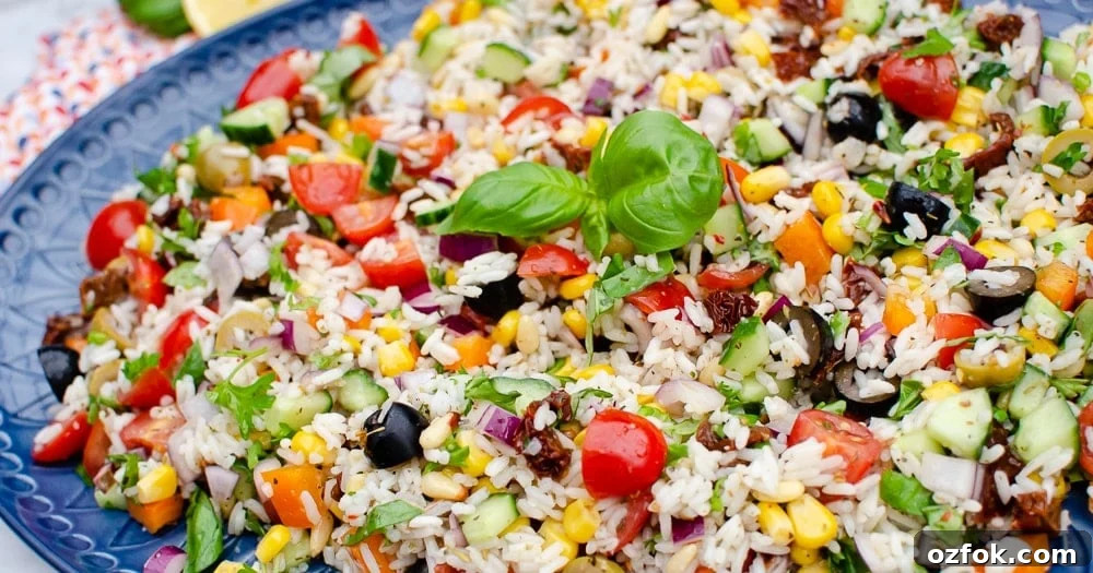 Italian Style Rice Salad on a large blue platter plate and basil leaves on top