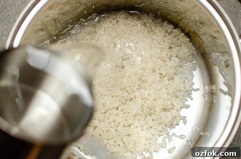 Water being poured onto our rice in a silver cooking pot