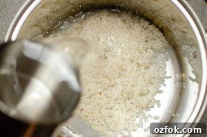 Water being poured onto our rice in a silver cooking pot