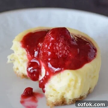 A close up of cupcake on a plate, with Cream cheese and raspberry