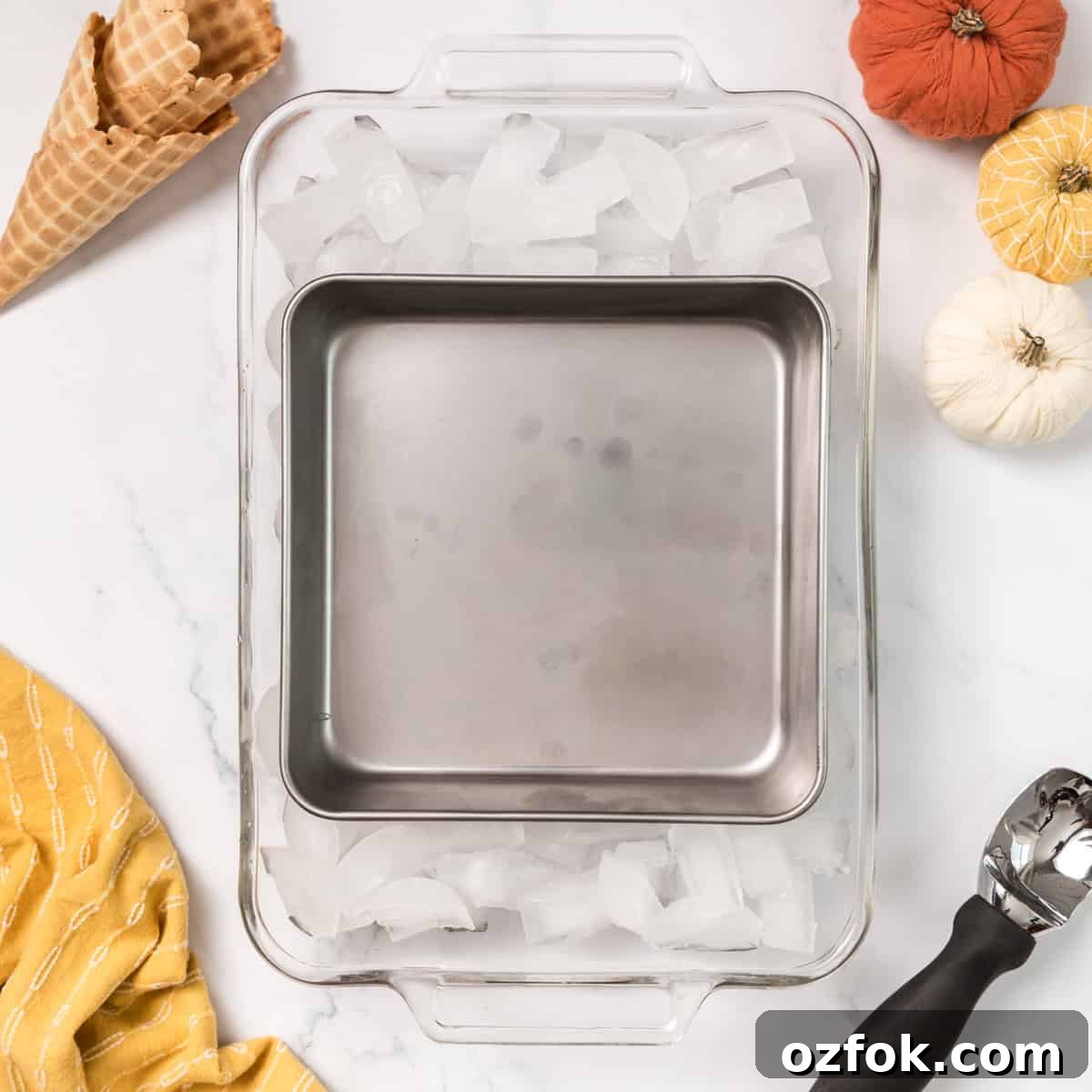 A metal pan inside of a glass pan with ice.