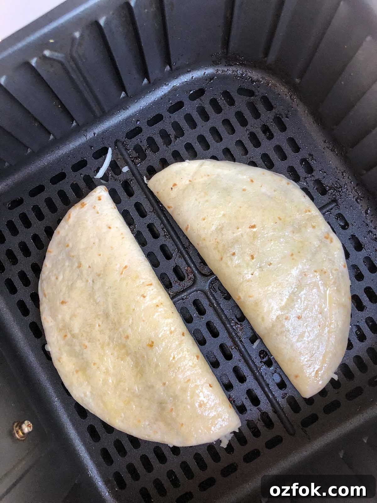uncooked quesadilla in air fryer basket