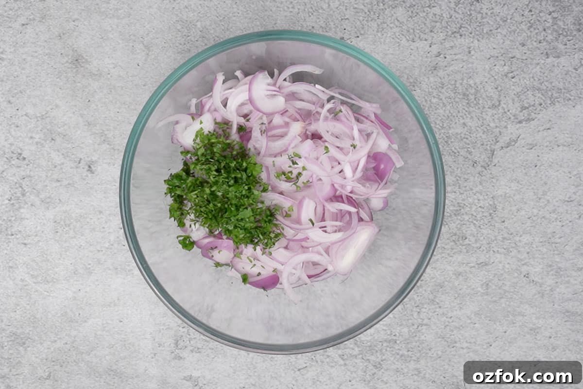 Sliced onions and chopped parsley added to a bowl.