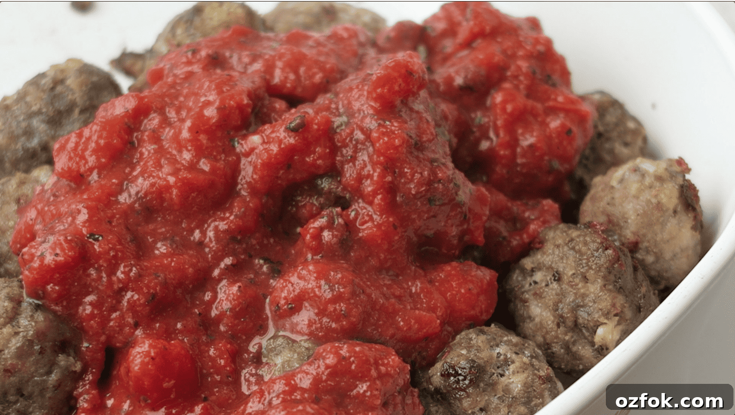 marinara poured over meatballs